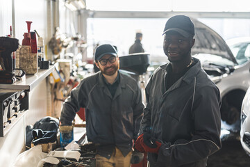 Multi-ethnic team of African and Caucasian men working in auto service. High quality photo