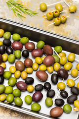 Multi-colored olives on a metal baking tray.