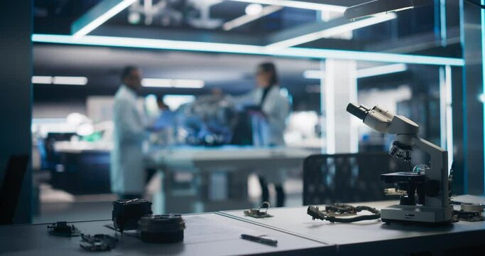 Workplace with a Modern Digital Microscope in a Research and Development Facility. Two Engineers or Scientists Working in High Tech Laboratory with Modern Equipment in the Background
