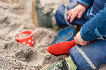 Cutout of toddler playing in sandbox