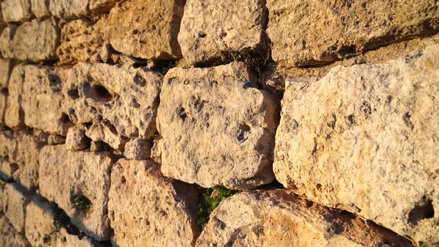 Ancient Stone Wall - Limestone. Fence is made of crude stone limestone on loam mortar. The millennial ancient methods of construction, history of the building
