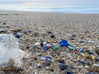 Plastic pollution on beach in Portugal, with Atlantic ocean in background. Environmental issues.