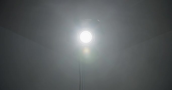 Video studio Fresnel lens spotlight on black background. lights slowly turn on and off. Close up.