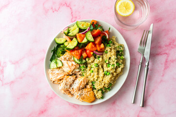 Healthy lunches, quinoa with green peas, with baked red fish salmon and fresh salad of tomato, cucumber and greens, top view