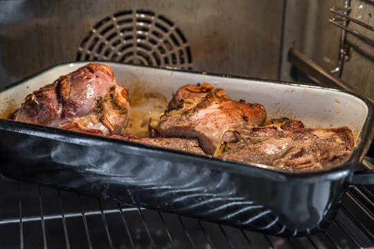 Echter herzhafter selbst gemachter Schweinebraten in einem Br&auml;ter Schmortopf im Ofen, Deutschland