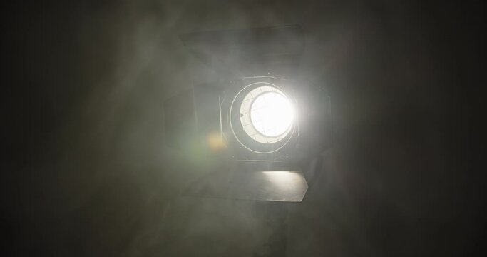 Large Studio halogen lamp with a lens and curtains made of metal Shine in the dark room in which to let loose the smoke from the generator machine