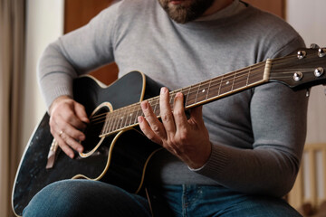Playing the guitar. Strumming acoustic guitar. Musician plays music. Man fingers holding mediator....
