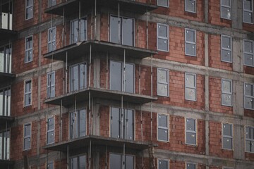 Scene of the brick semi-constructed apartment building with newly installed windows