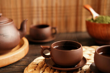 Tea Ceremony. Traditional Asian Tea Utensil, Serving Authentic Set. Person Pouring Tea from Brown Pottery Teapot to Teacup. Bamboo Tray. Lifestyle. Wellness Balance Health. Tea Brewing Equipment