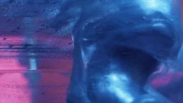 Vertical video. Paint drop. Ink water. Smoke cloud. Defocused blue pink color shiny fluid splash motion over neon light ice cube edge abstract background.