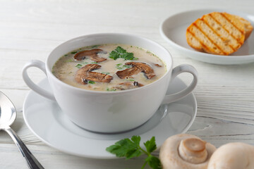 Mushroom cream soup on a white wooden board. side view