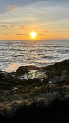 Vertical shot of abeautiful orange sunset over the sea.