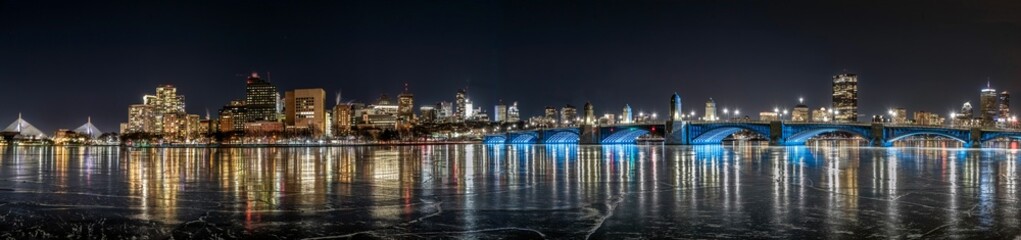 an icy river with many lights on and cityscape in the background
