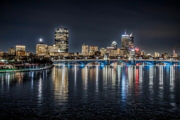 Fototapeta premium a night shot of the city from across the river with ice on the water