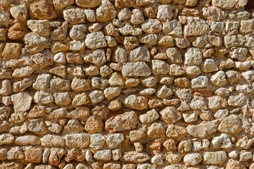 Rough stone wall texture background at the sunlight