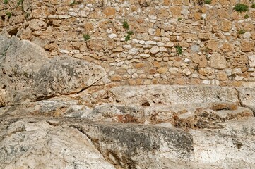 stone wall of a castle complex with a small room and arch