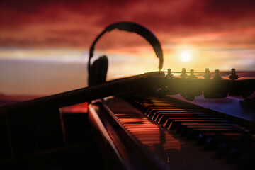 silhouette of synthesizer and acoustic guitar neck at colorful sunset