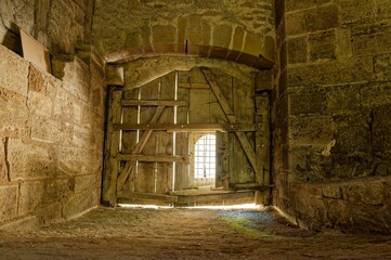 Inside of an old barn with a wooden door © M  Hieber/Wirestock Creators