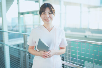 Fototapeta na wymiar タブレットを持った病院で勤務する女性医療従事者