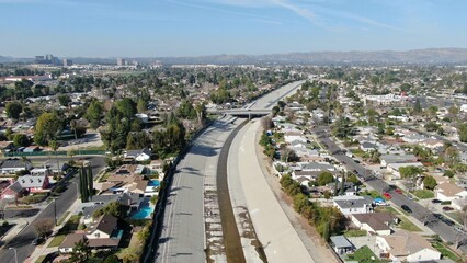 Drone shot of a bridge crossing over a water canal in a residential neighborhood on a sunny day