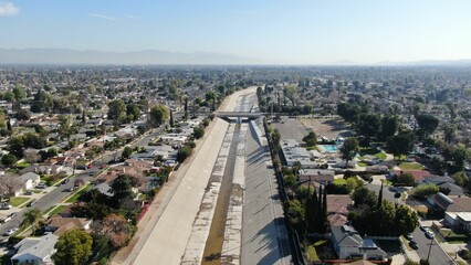 Bird's eye view of a bridge crossing over a water canal in a residential neighborhood on a sunny day