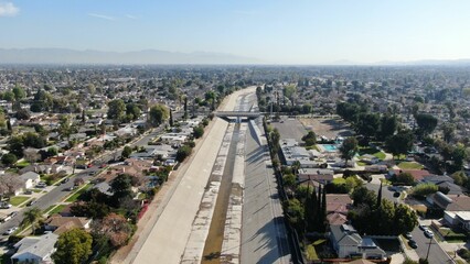 Aerial shot of a narrow river separating the city with the horizon in the background on a sunny day