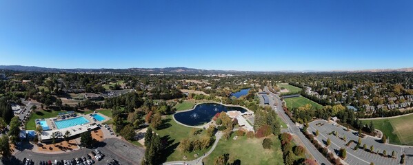 Aerial panoramic view of a lake and swimming pool in a park in Walnut Creek City, California