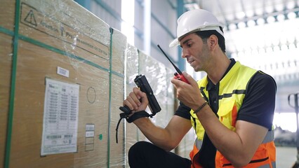 Professional young engineer man holding barcode scanner and radio communication talking with...