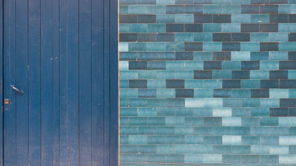 Puerta azul de madera y pared de baldosas azules