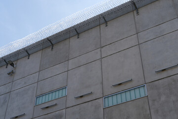 many rows of barbedwire, high concrete fence, barbed wire fence on top, building for execution of...