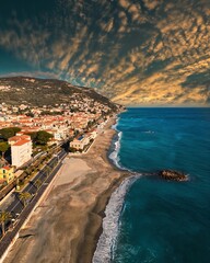 Beautiful view of the beach and sky from above, next to a town in Italy