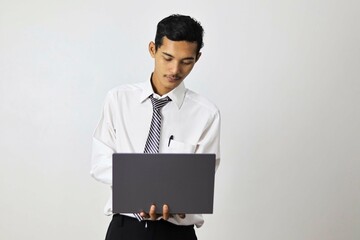 Successful young man using laptop, watching webinar, working remotely, online e-commerce e-learning...