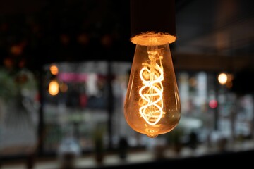 Old-style vintage light bulb in orange color in the restaurant