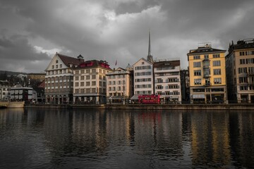 Fototapeta na wymiar Limmat quai and vintage buildings under a cloudy sky in Zurich Switzerland