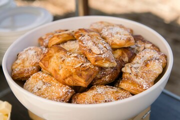 Closeup shot of a bowl of freshly baked pastries with powdered sugar