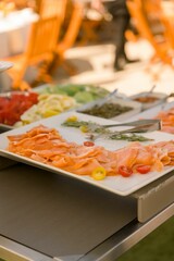 Vertical shot of fresh salmon with cherry tomatoes on a white board.