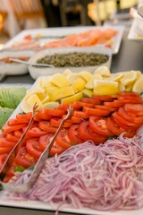 Vertical closeup shot of sliced avocados, tomatoes, and lemons on a table