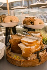 Vertical shot of a platter of sliced bread and bagels at a dinner buffet
