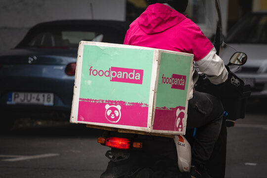 SZEGED, HUNGARY - SEPTEMBER 19, 2022: Foodpanda Delivery man in Szeged with a bag with its logo. Food Panda is a german mobility company app specialized in food delivery, part of Delivery Hero.