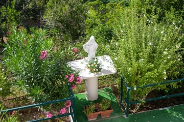 Photo sur Plexiglas Monument historique High angle shot of a white statue in a garden with lush vegetation