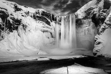 an ice fall on the side of a snowy mountain by some ice formations