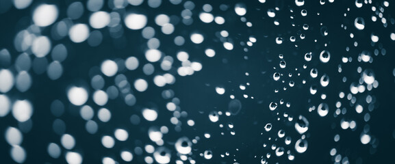 Naklejka na ściany i meble Atmospheric minimal monochrome backdrop with rain droplets on glass. Wet window with rainy drops and dirt spots closeup. Blurry minimalist background of dirty window glass with raindrops close up.