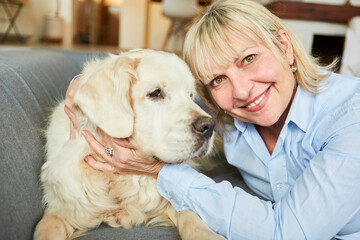 Happy senior woman cuddling with retriever dog