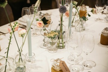 Table decorated with natural flowers, glasses and white tablecloth for wedding ceremony