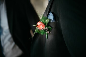 Boutonniere in the pocket of the groom's jacket during the wedding ceremony