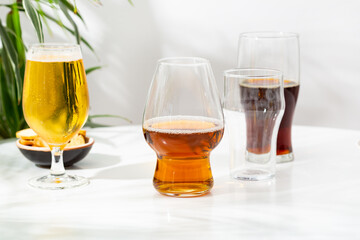 Glass with light beer dark empty on light background