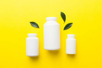 supplement pills with medicine bottle health care and medical top view. Vitamin tablets. Top view mockup bottle for pills and vitamins with green leaves, natural organic bio supplement, copy space