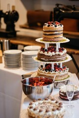 Vertical closeup of a cake with berries on a tiered tray at a banquet
