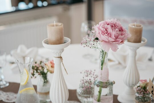 Closeup of a decorated table with flowers in a vase and candles ready for a wedding celebration