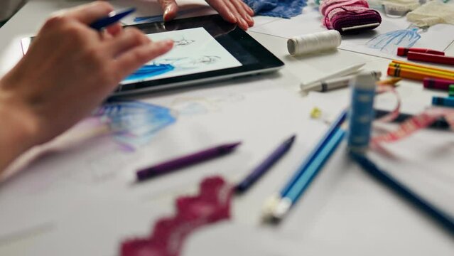 The business owner is engaged in the creation of fashion design. Production concept. In the process of creating The dress is bright. Close-up The artist embodies his ideas on the place of the worker, 